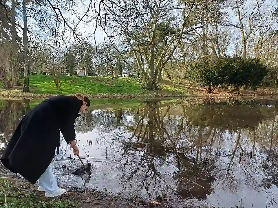 Eine Sch&uuml;lerin beobachtet Lebewesen im Gew&auml;sser 