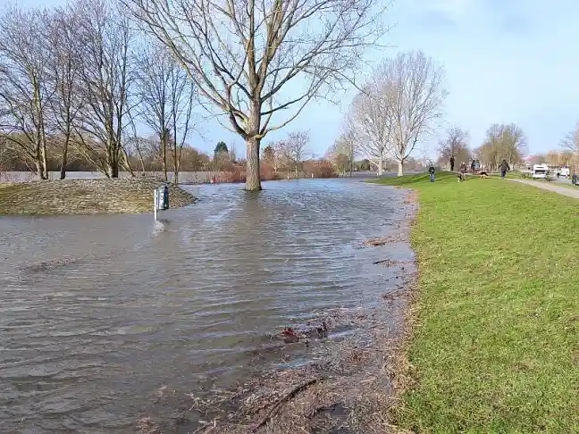 Foto vom Fluss Weser, der einen hohen Wasserstand an einem kleinen Deich hat.